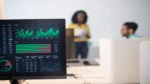 Best AI search optimization services — real photo of a monitor showing green analytics charts in an office