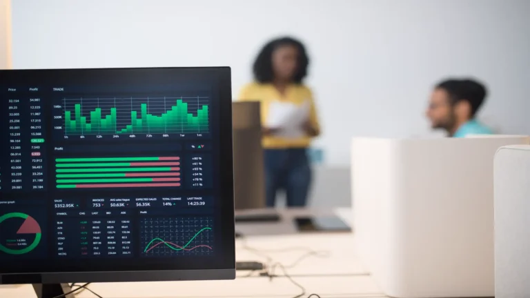 Best AI search optimization services — real photo of a monitor showing green analytics charts in an office