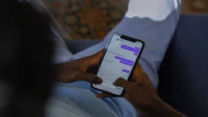 Claude AI free online — real photo of hands texting in a chat app on a smartphone