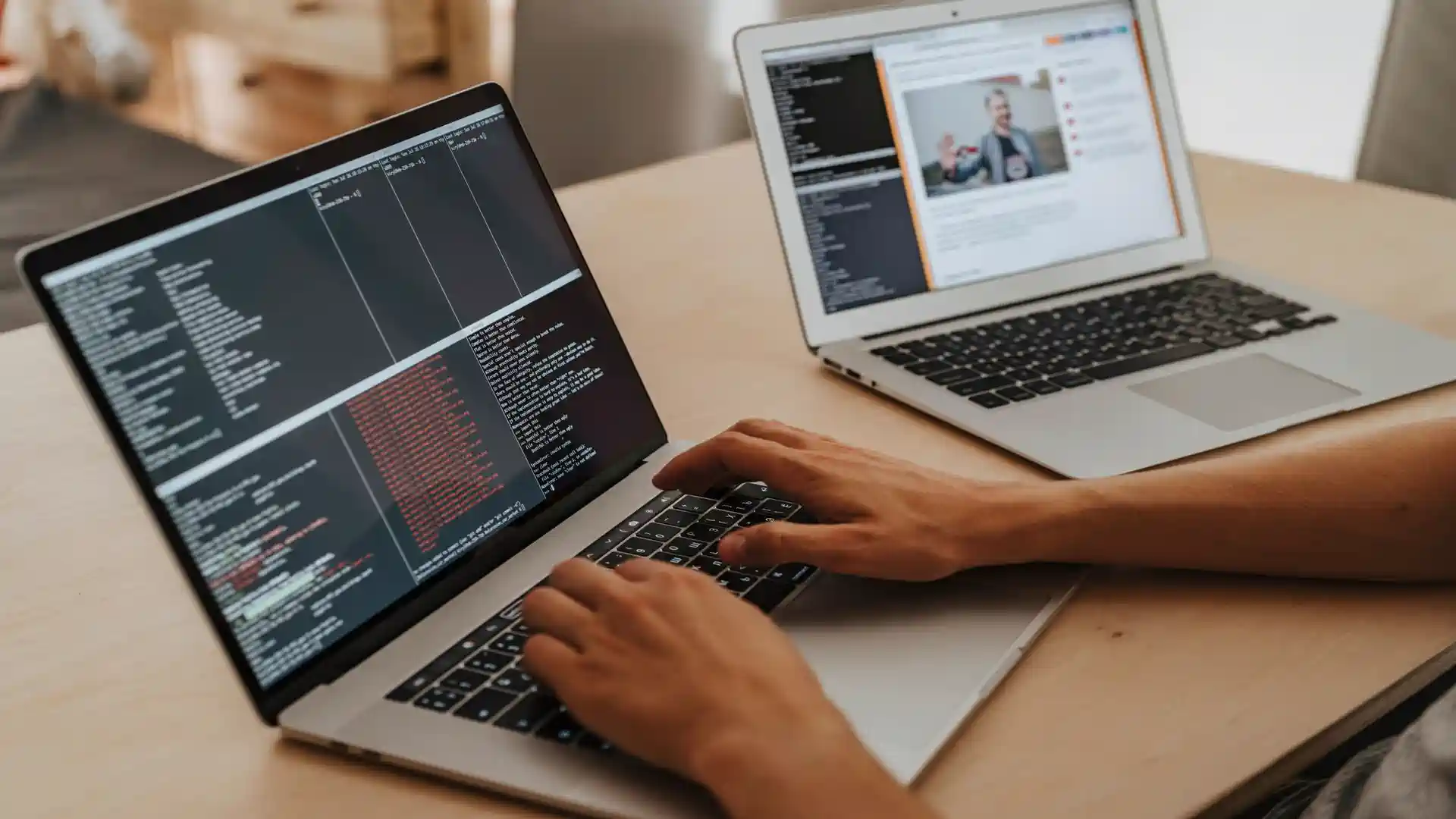AI SEO agent for small business — real photo of hands typing code on a laptop beside a second laptop