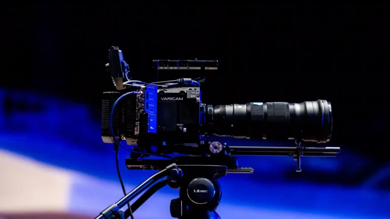 Runway AI video generator — real photo of a professional cinema camera on a tripod under blue lighting