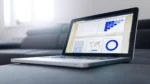 HubSpot AEO AI search optimization — real photo of a laptop showing an analytics dashboard with charts and a map