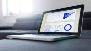 HubSpot AEO AI search optimization — real photo of a laptop showing an analytics dashboard with charts and a map