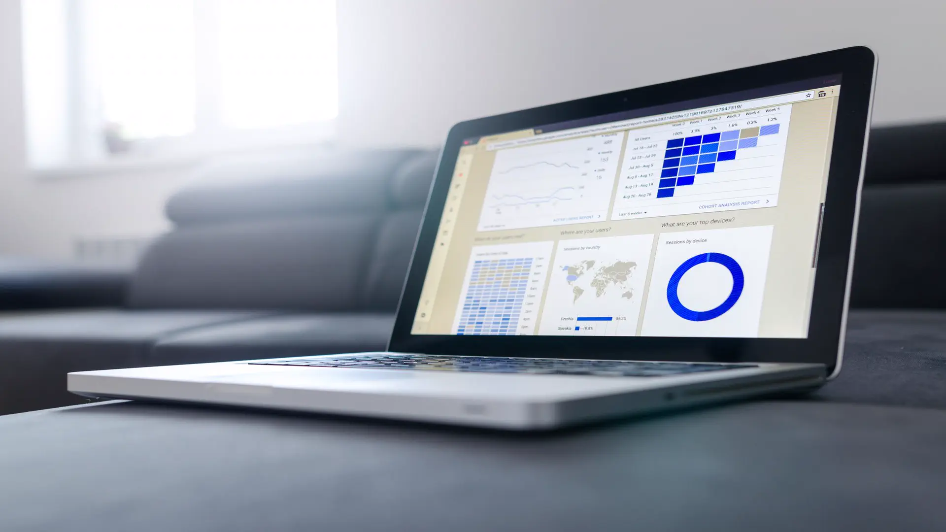 HubSpot AEO AI search optimization — real photo of a laptop showing an analytics dashboard with charts and a map