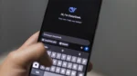 how to rank in perplexity — Close-up of a hand holding a smartphone displaying an AI chatbot conversation screen with a message input box and an on-screen keyboard