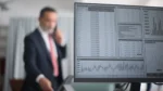 generative engine optimization tools — Computer monitor displaying a data dashboard with tables, bar charts and candlestick graphs, with a businessman blurred in the background
