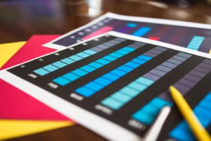 Free AI infographic generator online — real photo of printed colorful bar charts and infographics on a desk with a yellow pencil