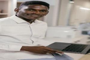 AI LinkedIn post generator — real photo of a smiling professional man in a white shirt holding a laptop in a bright office