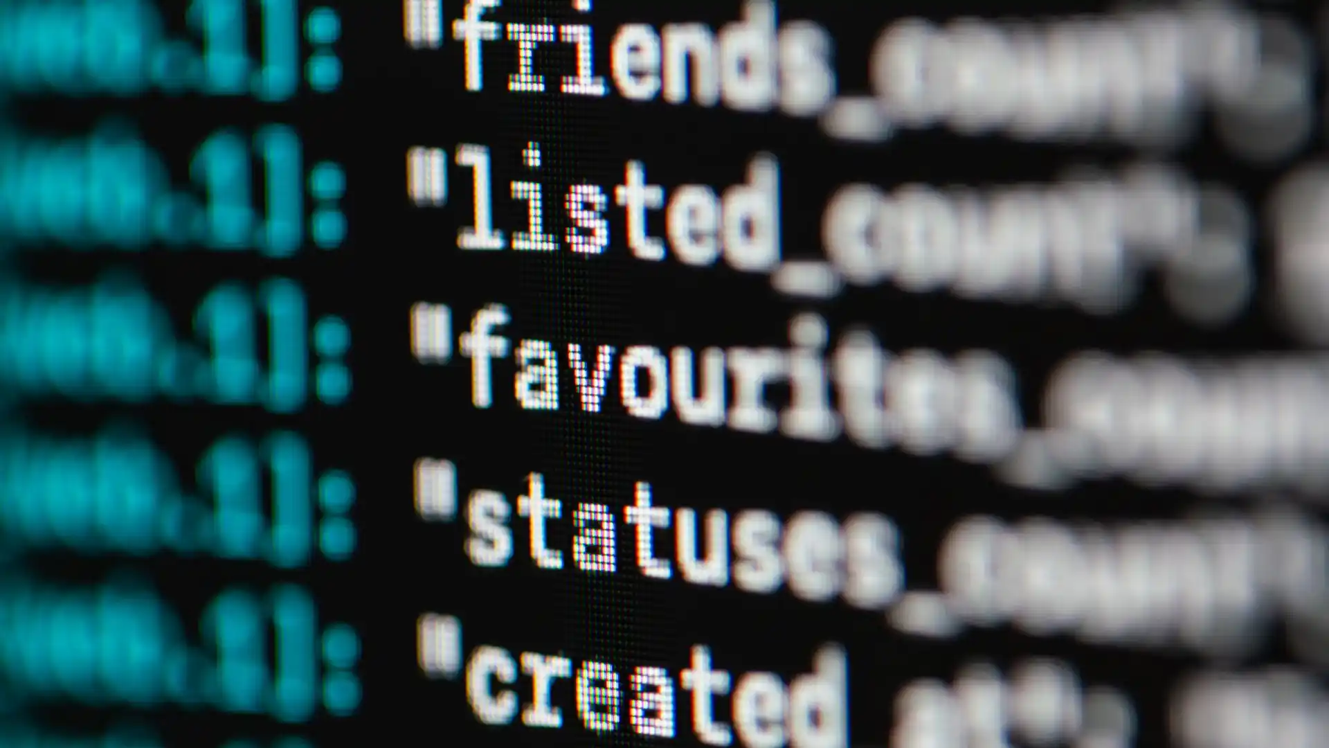 ai regex generator free — Extreme close-up of code on a dark screen showing text fields like friends_count, listed_count, favourites, statuses and created