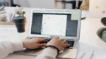 Automate cold email follow-ups with AI — real photo of a person typing on a laptop showing an email inbox app