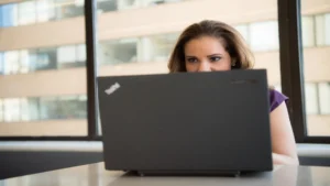 Build AI automation workflow without coding — real photo of a woman working on a laptop in a bright office