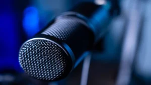 AI voice cloning for beginners — real photo of a close-up studio microphone with blue lighting