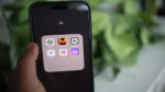 OpenAI GPT — real photo of a hand holding a smartphone showing an AI apps folder