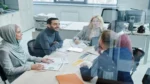 AI lead generation tools — real photo of a business team meeting around a conference table with documents
