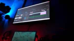 AI video editing tools for YouTubers — real photo of a monitor showing a video editing timeline in a dark studio