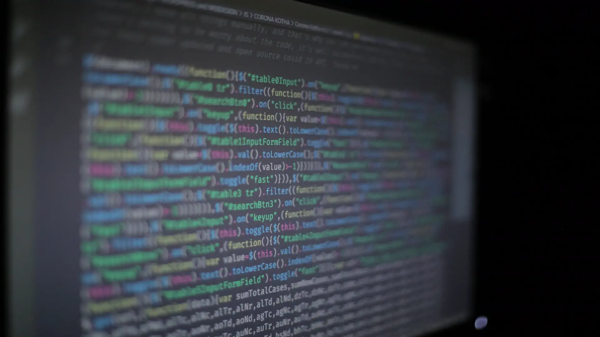 AI code review tools — real photo of colorful programming code on a dark screen