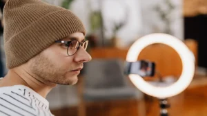 YouTube Shorts voice AI — real photo of a man recording video on a smartphone with a ring light
